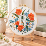 Orange poppies and letter r embroidery kit finished hoop displayed on a wooden stand as cosy tabletop decor