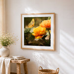 Orange ranunculus and butterfly cross stitch artwork displayed on wall as home decor