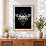 Finished ornamental luna moth cross stitch artwork displayed