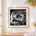 Finished owl eye close-up cross stitch artwork displayed