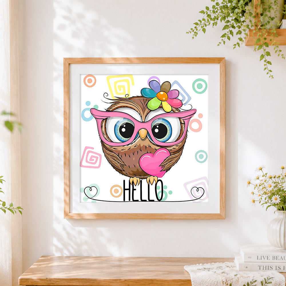 Finished owl with pink glasses and heart cross stitch artwork displayed