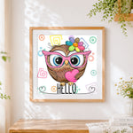 Finished owl with pink glasses and heart cross stitch artwork displayed