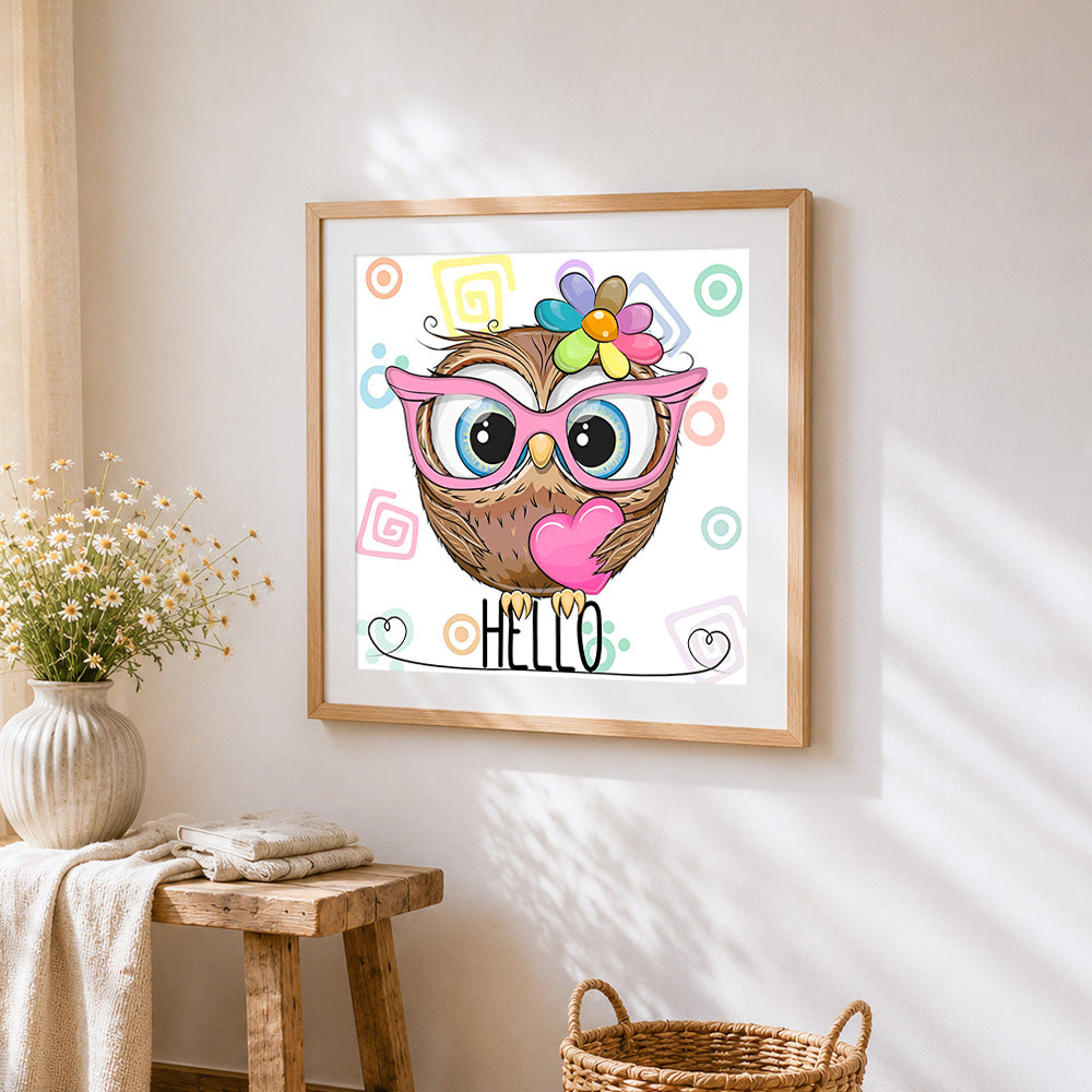 Owl with pink glasses and heart cross stitch artwork displayed on wall as home decor