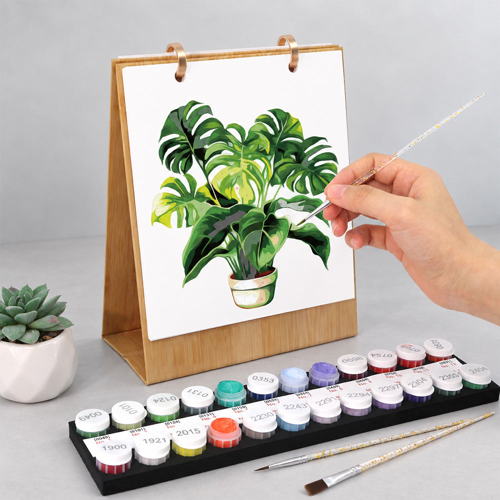 Hand painting a green monstera plant on the Botanical Greens Paint by Numbers Desk Calendar
