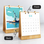 Front and back view of the Iconic Landmarks desk calendar showing monthly dates and a finished Statue of Liberty painting