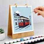 Hand painting a vintage red tram illustration on the On the Move Paint by Numbers Desk Calendar