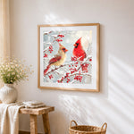 Pair of cardinals in the snow cross stitch artwork displayed on wall as home decor