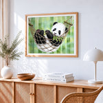 Panda cub in a hammock cross stitch artwork displayed on wall as home decor