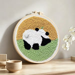 Panda in the meadow punch needle artwork displayed on a table