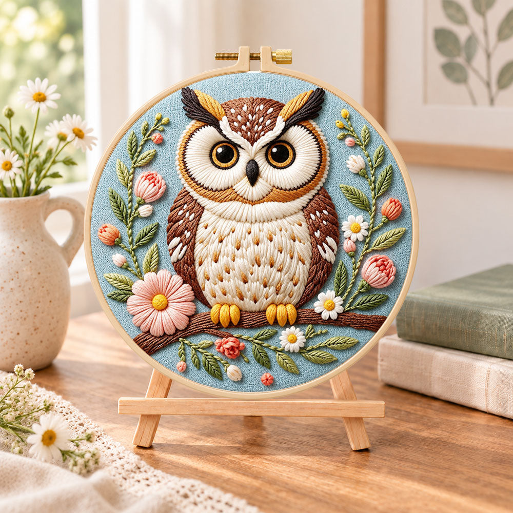 Pastel floral owl embroidery kit finished hoop displayed on a wooden stand as cosy tabletop decor