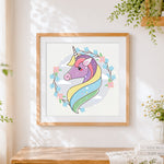 Finished pastel unicorn portrait with floral wreath cross stitch artwork displayed