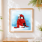 Finished penguin with red scarf in snow cross stitch artwork displayed