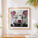 Finished pig with white floral crown cross stitch artwork displayed
