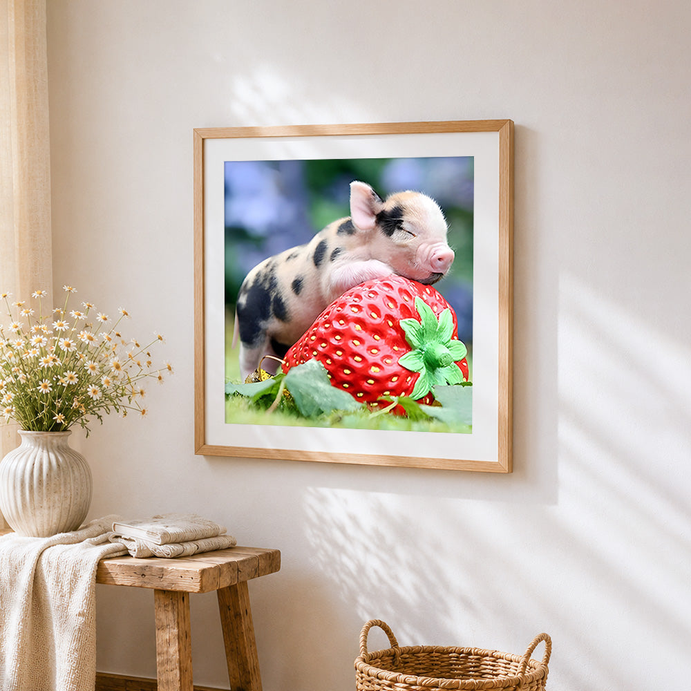 Piglet sleeping on giant strawberry cross stitch artwork displayed on wall as home decor