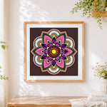 Finished pink and purple floral mandala cross stitch artwork displayed