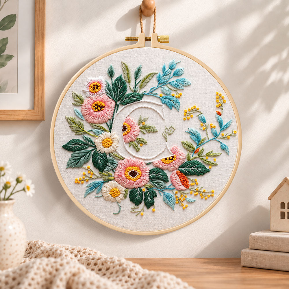 Pink botanical blooms and letter c embroidery hoop wall art displayed as warm and cosy handmade home decor