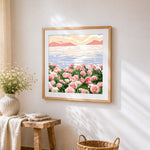 Pink flowers by the sea cross stitch artwork displayed on wall as home decor