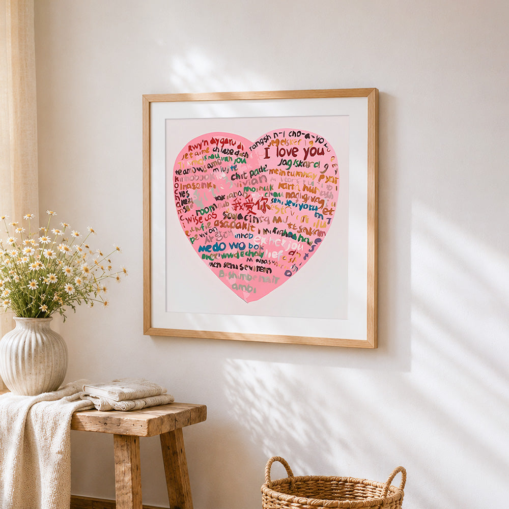 Pink multi language i love you heart cross stitch artwork displayed on wall as home decor