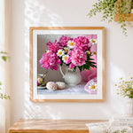 Finished pink peonies and white daisies cross stitch artwork displayed