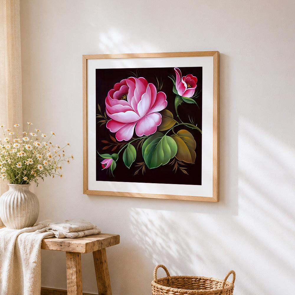Pink rose and buds on dark background cross stitch artwork displayed on wall as home decor