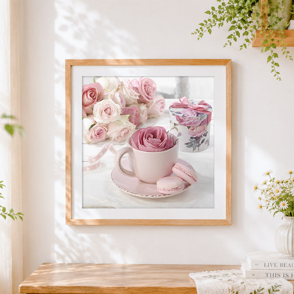 Finished pink rose in a teacup with macarons cross stitch artwork displayed