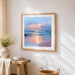 Pink sunset over ocean waves cross stitch artwork displayed on wall as home decor