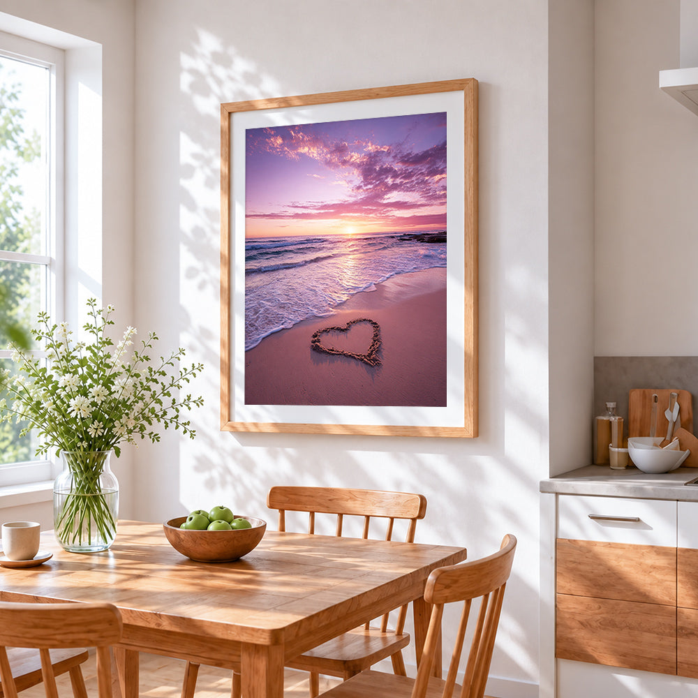 Pink sunset shoreline with sand heart cross stitch artwork displayed on wall as home decor