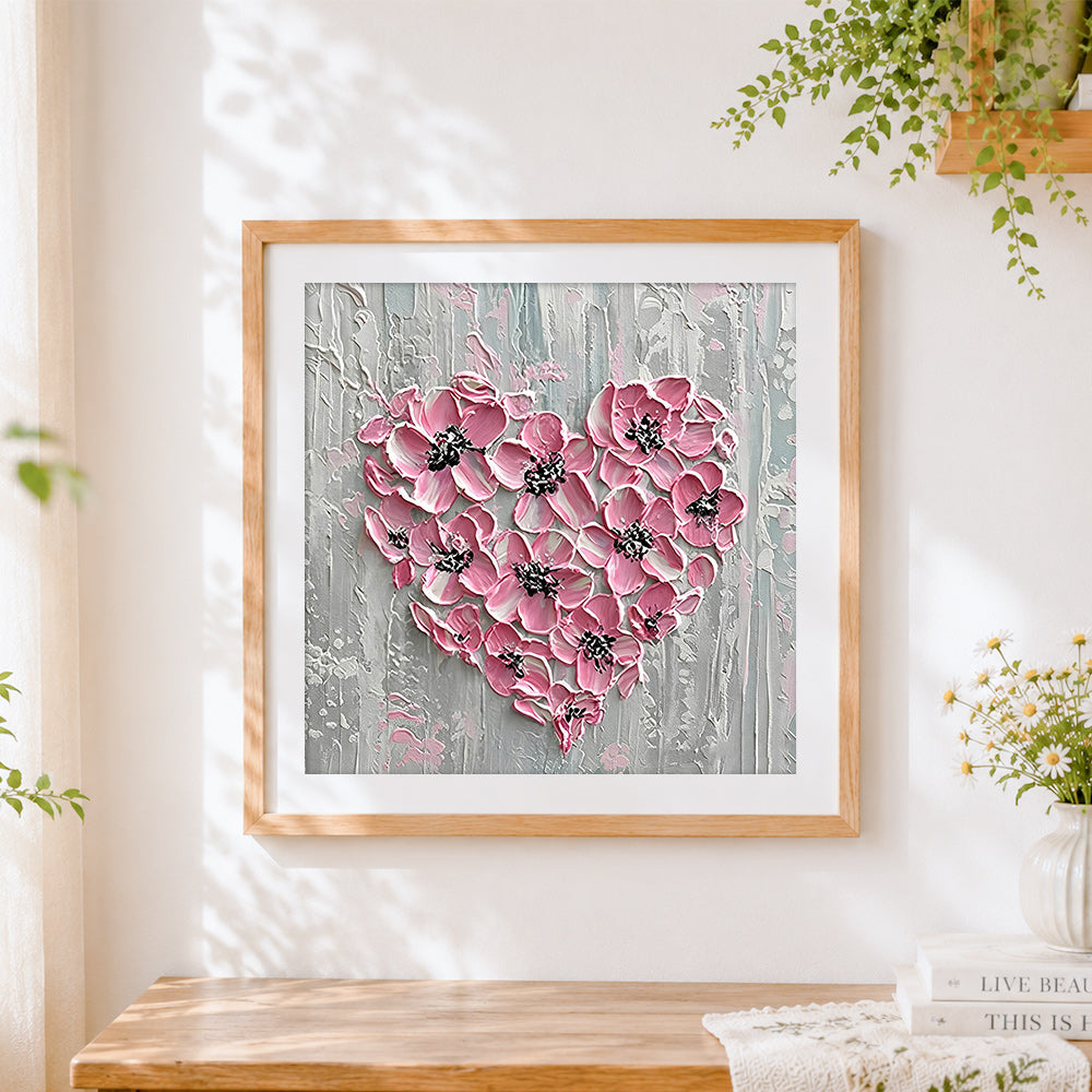 Finished pink textured floral heart cross stitch artwork displayed