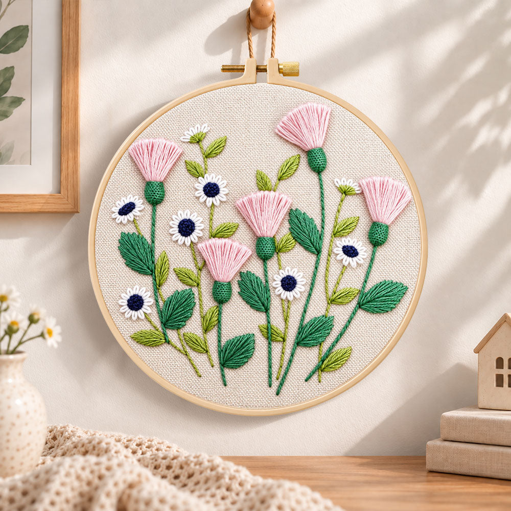 Pink thistle and daisies embroidery hoop wall art displayed as warm and cosy handmade home decor