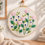 Pink thistle and daisies embroidery hoop wall art displayed as warm and cosy handmade home decor