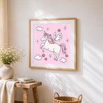 Pink unicorn with wings cross stitch artwork displayed on wall as home decor