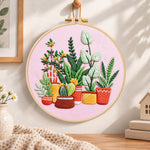 Potted plants on pink fabric embroidery hoop wall art displayed as warm and cosy handmade home decor