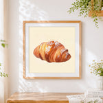 Finished powdered sugar croissant cross stitch artwork displayed