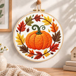 Pumpkin wreath with fall foliage embroidery hoop wall art displayed as warm and cosy handmade home decor