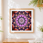 Finished purple and gold glowing mandala cross stitch artwork displayed