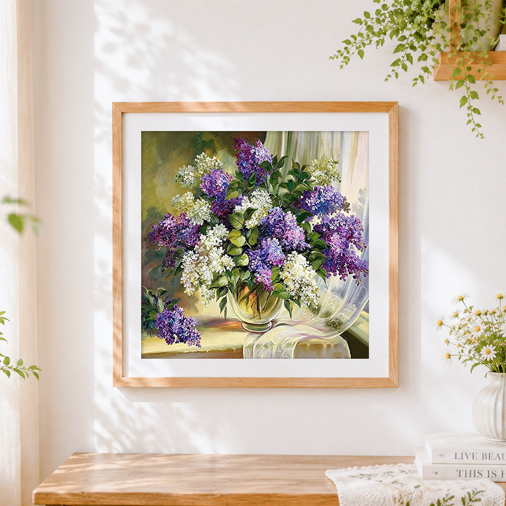 Finished purple and white lilacs in a vase cross stitch artwork displayed