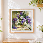 Finished purple and white lilacs in a vase cross stitch artwork displayed