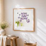 Purple butterflies and home sweet home sign cross stitch artwork displayed on wall as home decor