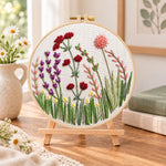 Purple meadow flowers embroidery kit finished hoop displayed on a wooden stand as cosy tabletop decor