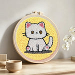 Quiet little white cat punch needle artwork displayed on a table