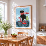 Quirky black cat on bicycle cross stitch artwork displayed on wall as home decor