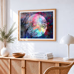 Rainbow full moon and tree branches cross stitch artwork displayed on wall as home decor
