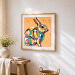 Rainbow rabbit cross stitch artwork displayed on wall as home decor
