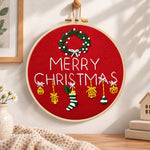 Red christmas greeting embroidery hoop wall art displayed as warm and cozy handmade home decor