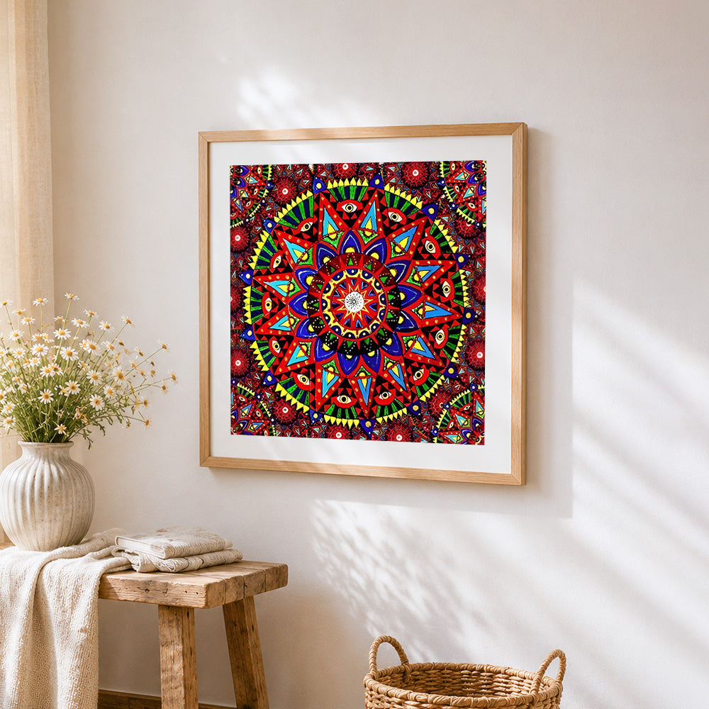 Red geometric mandala with eyes cross stitch artwork displayed on wall as home decor