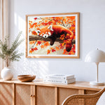 Red panda sleeping in autumn leaves cross stitch artwork displayed on wall as home decor