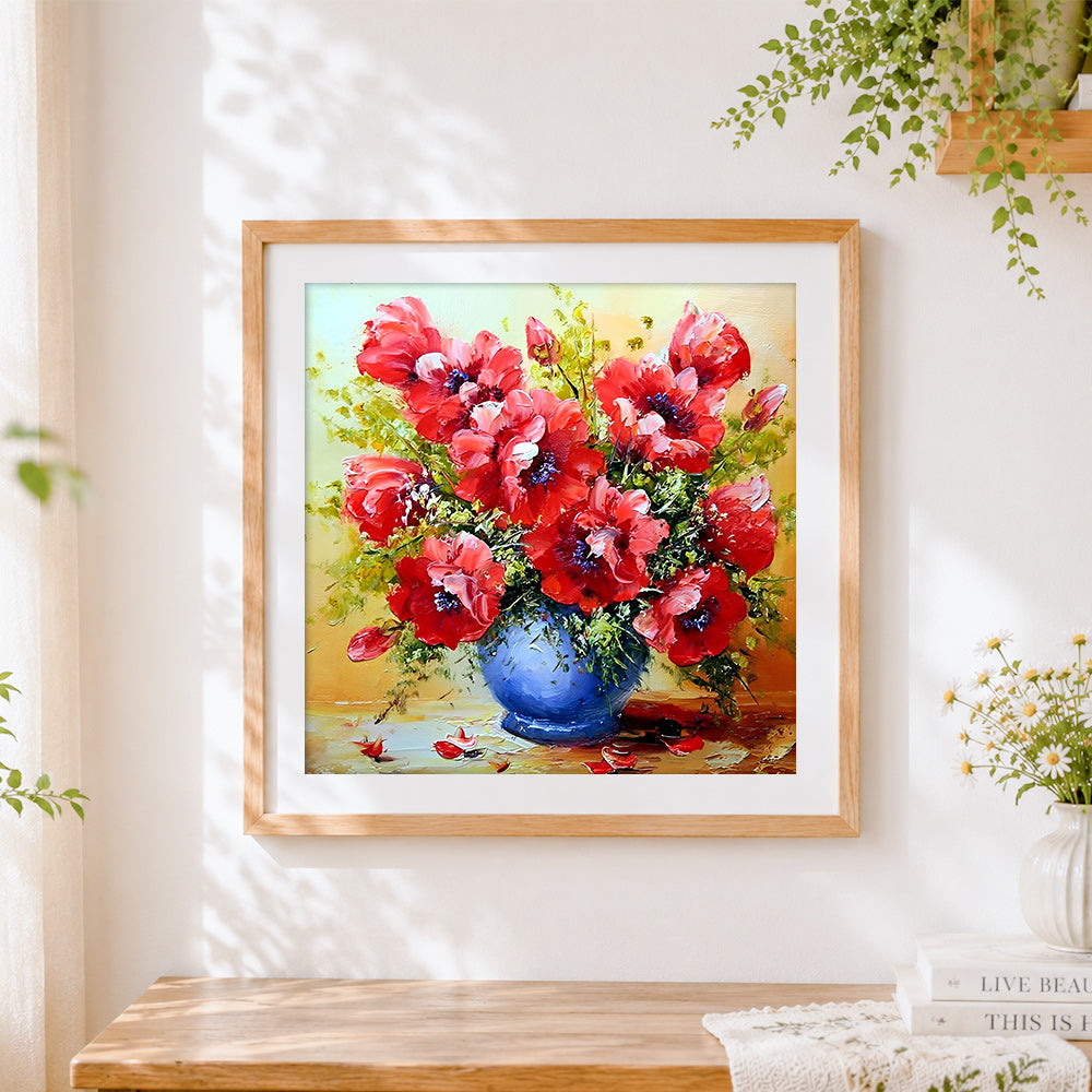 Finished red poppies in a blue vase cross stitch artwork displayed