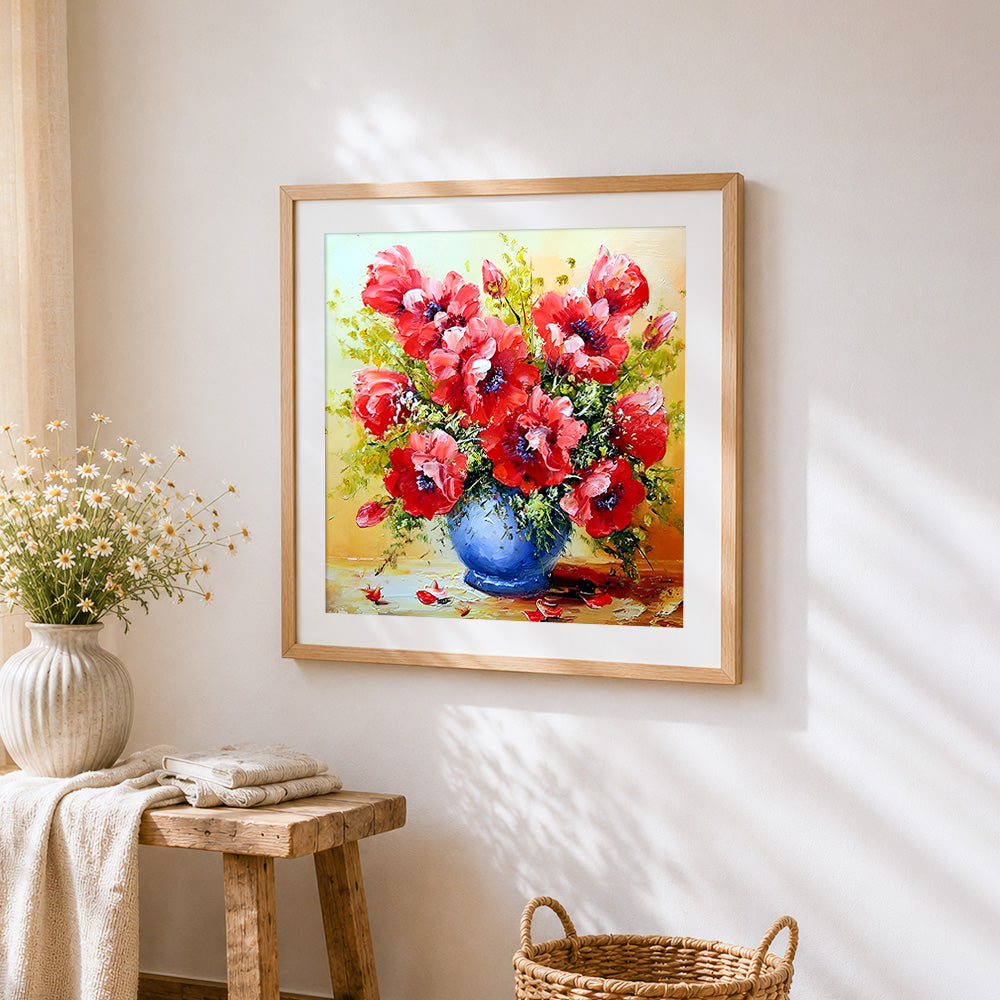 Red poppies in a blue vase cross stitch artwork displayed on wall as home decor
