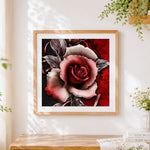 Finished red rose and black vines cross stitch artwork displayed