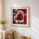 Red rose and black vines cross stitch artwork displayed on wall as home decor